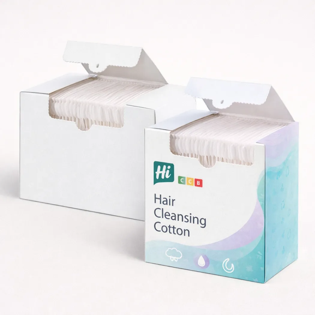 Two white boxes of hair cleansing cotton pads- one plain and one with blue branding-